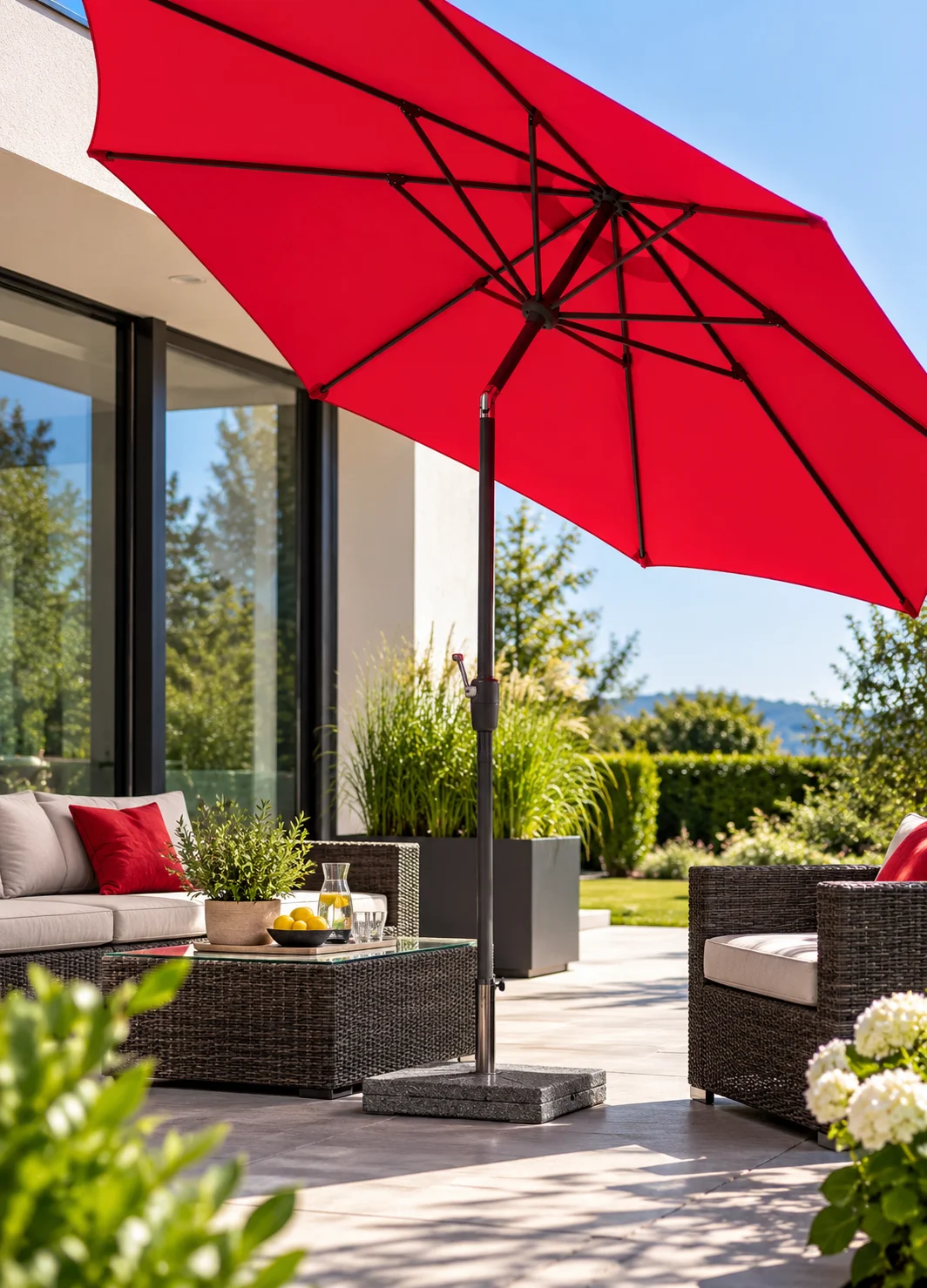 Kräftig roter Sonnenschirm auf einer modernen Terrasse