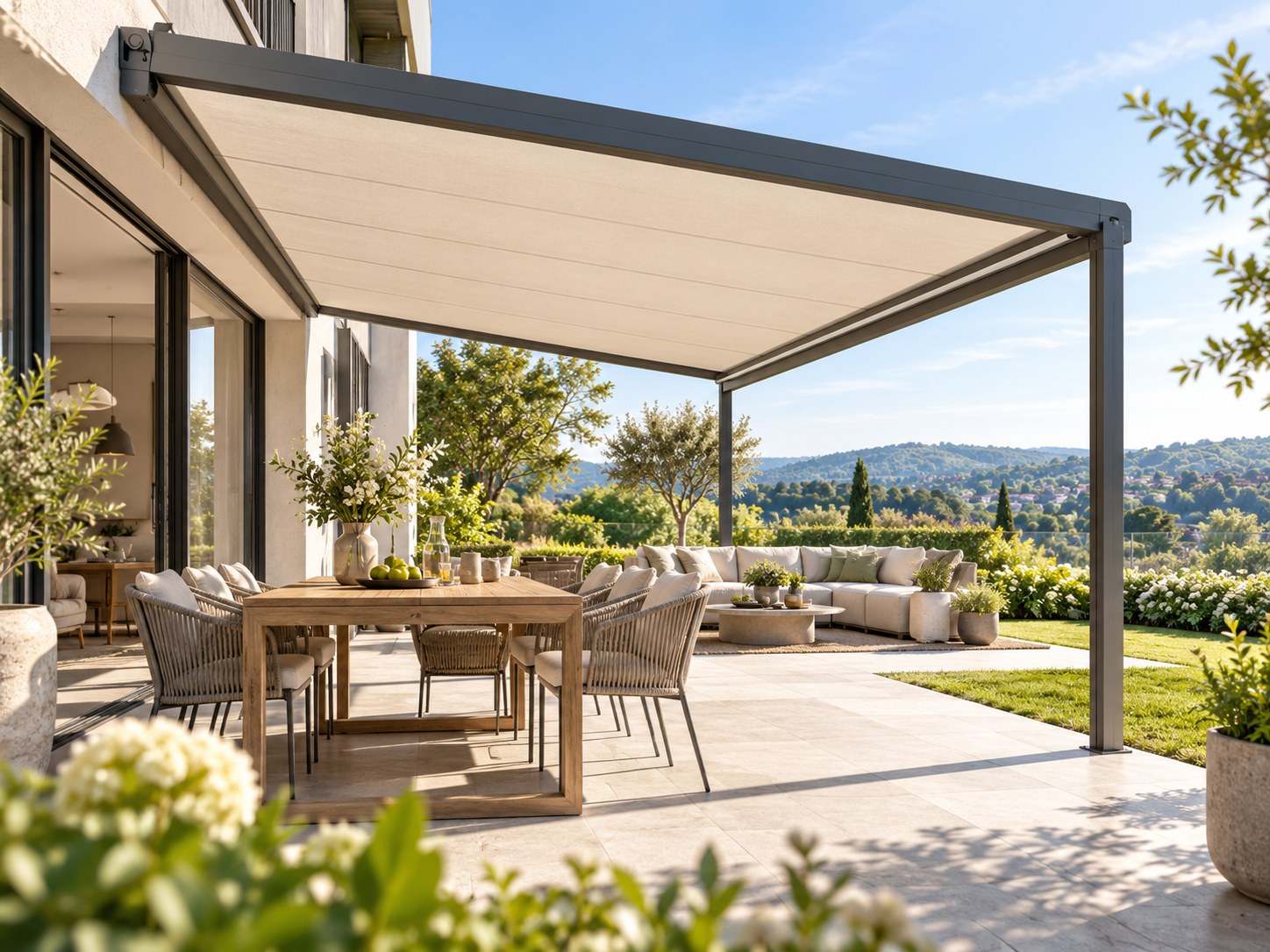 Helle Pergolamarkise über einem großzügigen Ess- und Loungebereich mit gepflegtem Garten und weitem Landschaftsblick
